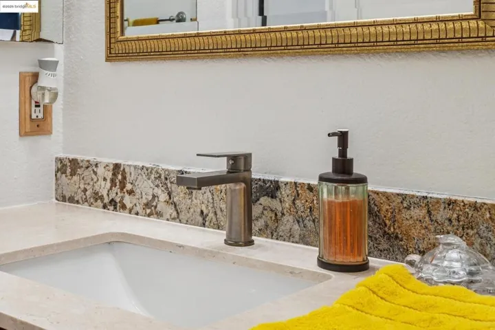 Bathroom view of vanity and a textured wall