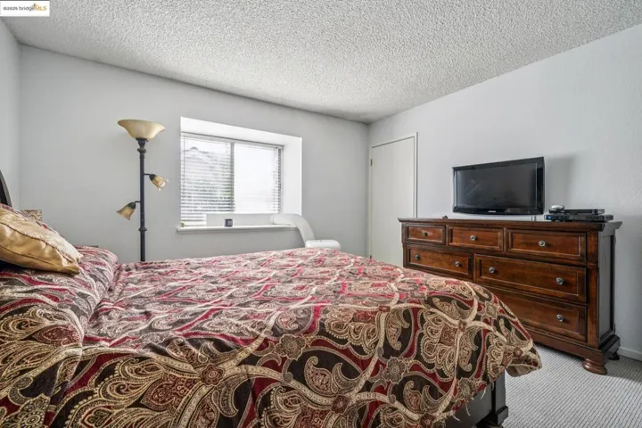 Bedroom featuring carpet floors and a textured ceiling