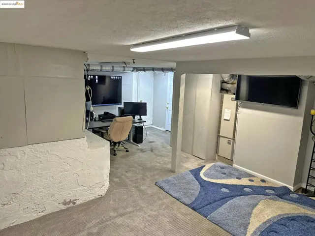 Office featuring a textured ceiling and carpet