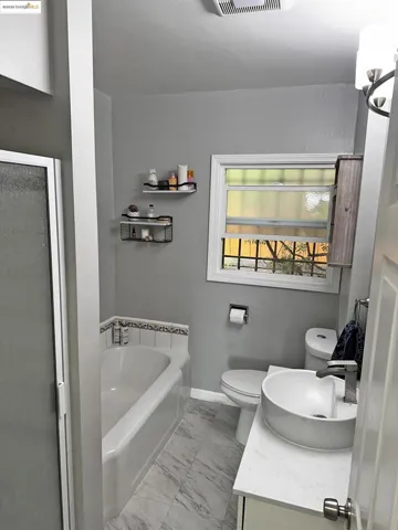 Bathroom featuring a bath, light marble finish floors, vanity, and a shower stall