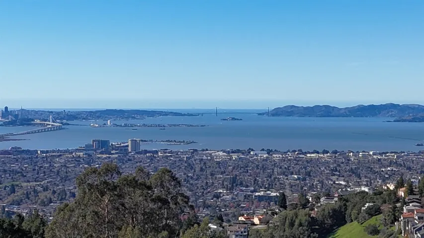 Water view featuring nearby urban area and a notable bridge