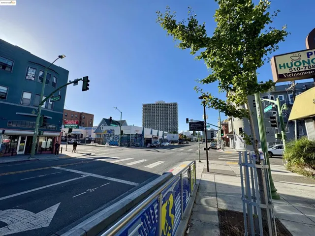 View of asphalt road with sidewalks, curbs, traffic lights, and street lighting