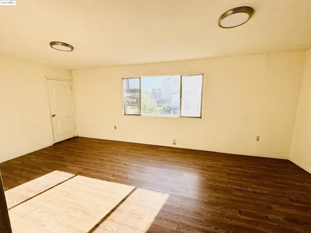 Spare room featuring dark wood-type flooring