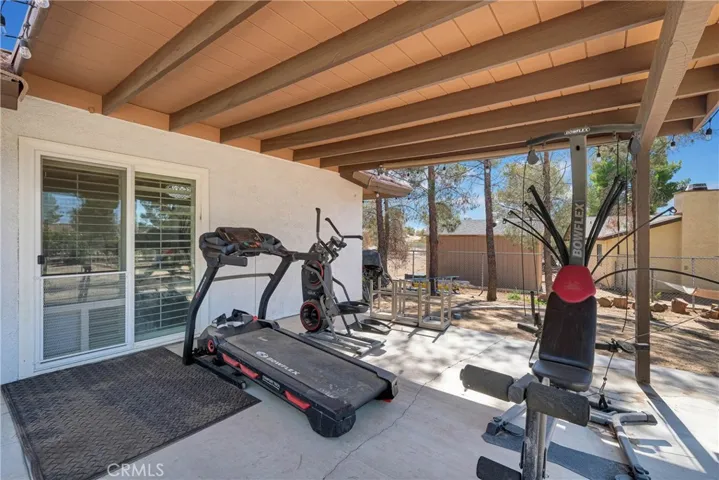 Backyard covered patio is fully cemented and access to living area, primary bedroom and sunroom.