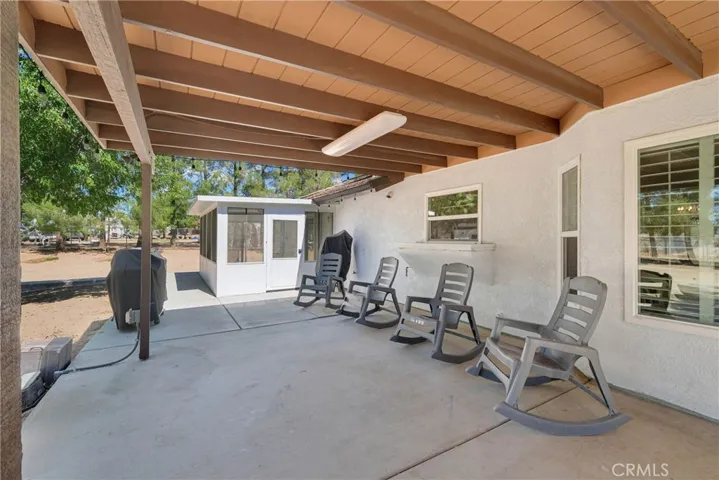 Sunroom has its own separate exit leading into covered backyard patio hooked up with electric, and ready for entertaining your guests.
