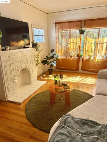 Living area with wood finished floors, crown molding, and a fireplace