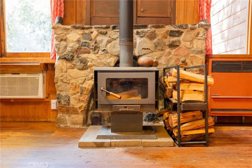 Wood burning stove with firewood rack. In wall air conditioner and propane heater.