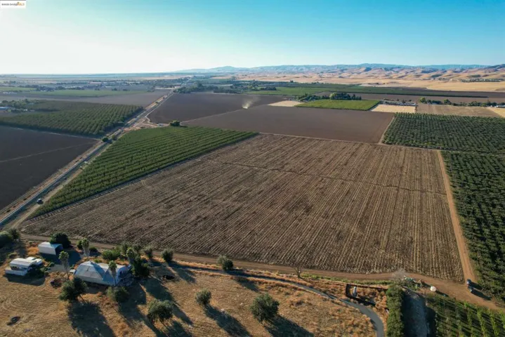 Aerial view of property's location with rural landscape, extensive farmland, and a mountainous background