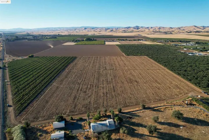 Aerial overview of property's location featuring a mountain backdrop, farmland, and rural landscape