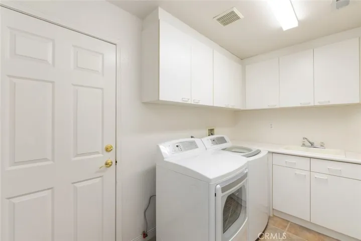 Convenient separate laundry room with storage and a utility sink