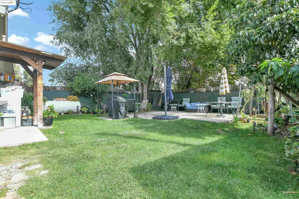 Fenced backyard featuring a patio and a gazebo