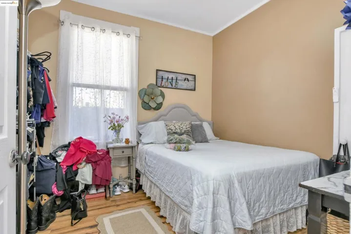 Bedroom with wood finished floors and crown molding