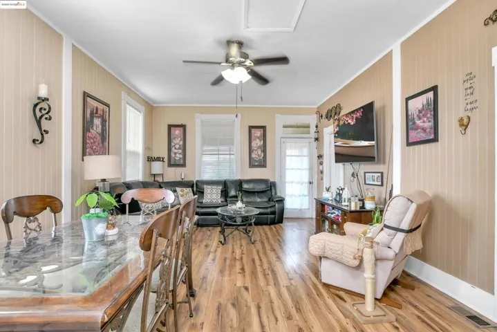 Dining room featuring ceiling fan, light wood-style flooring, and ornamental molding