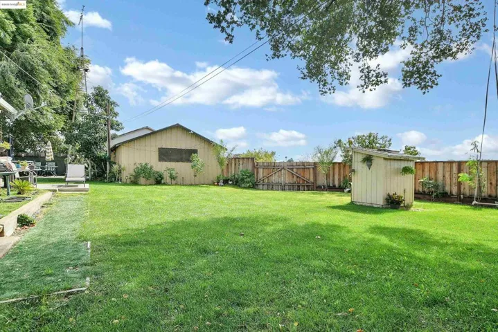 Fenced backyard with a storage shed