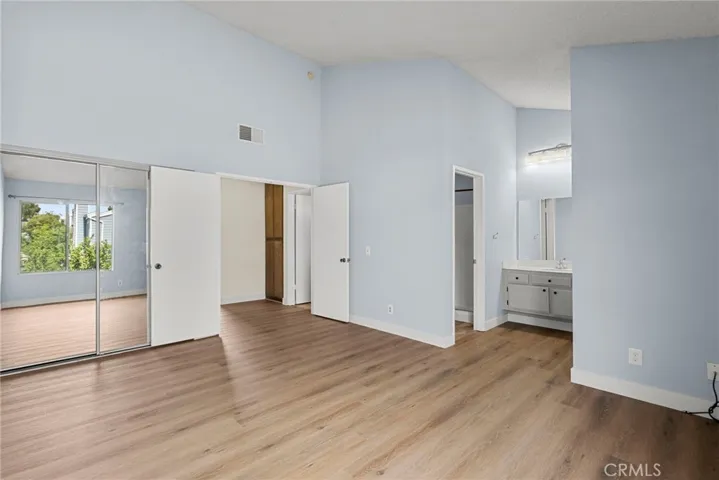 Primary Bedroom with Mirrored closet doors and entryway in view