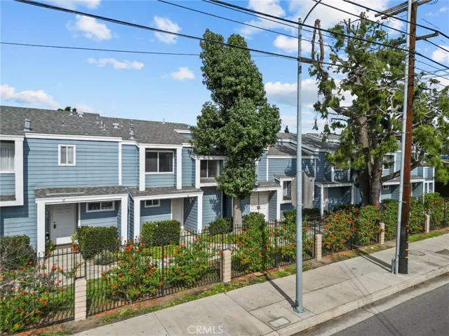 Front of building with sidewalk, rod iron fence