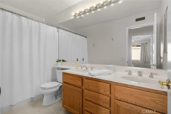 Shared hall bathroom upstairs with shower and tub and dual vanities.