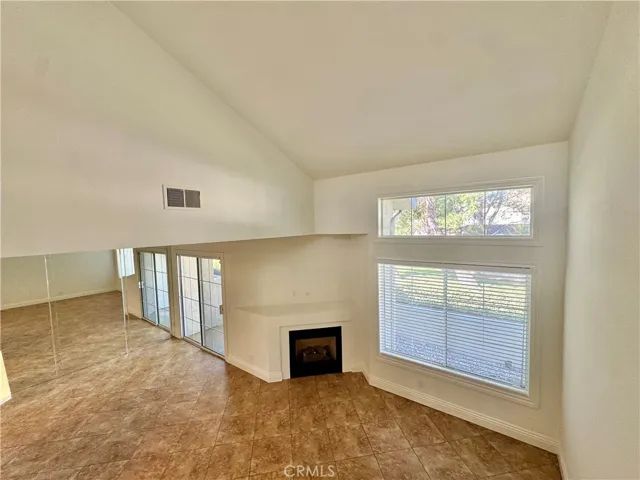 Cathedral ceilings in the living room with fireplace and open to dining room with access to rear patio