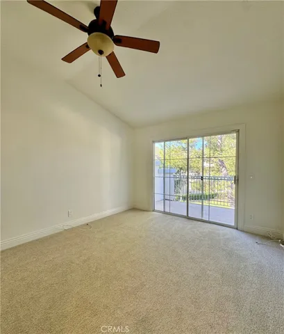 Primary bedroom with vaulted ceilings and private balcony