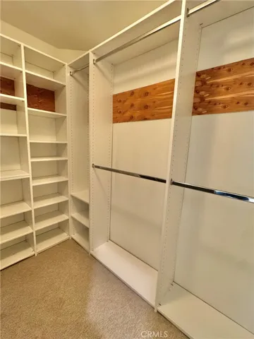 Walk-in closet in primary bedroom with custom organizers