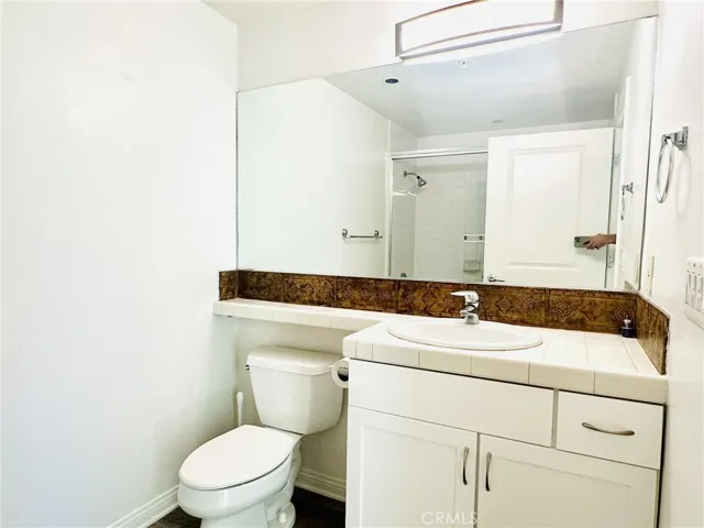 Secondary bathroom with large mirror and full vanity.