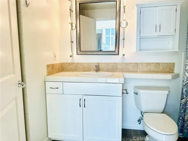 Primary bathroom with vanity and compact mirror.