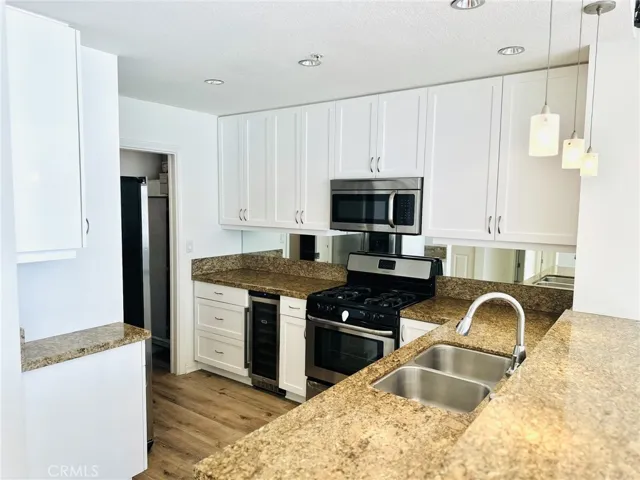 Updated kitchen with white cabinetry, granite countertops, and stainless appliances.