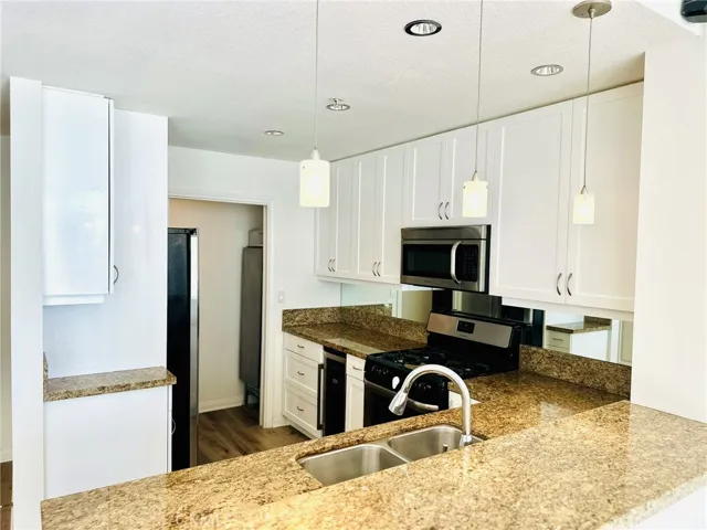 Kitchen entry view showcasing granite counters and white cabinetry.