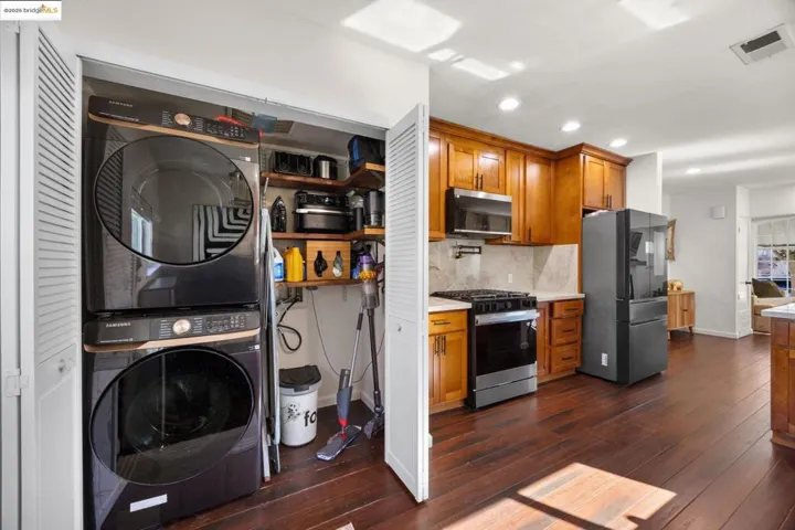 Kitchen featuring brown cabinetry, stainless steel appliances, recessed lighting, tasteful backsplash, and dark wood finished floors