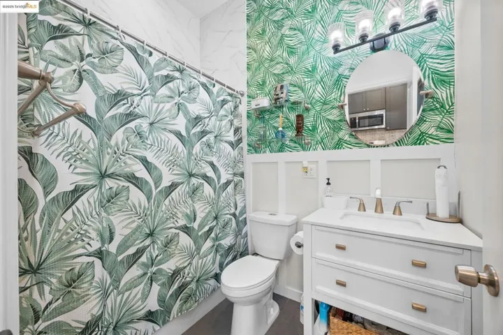 ADU - Full bath featuring vanity, curtained shower, and wallpapered walls