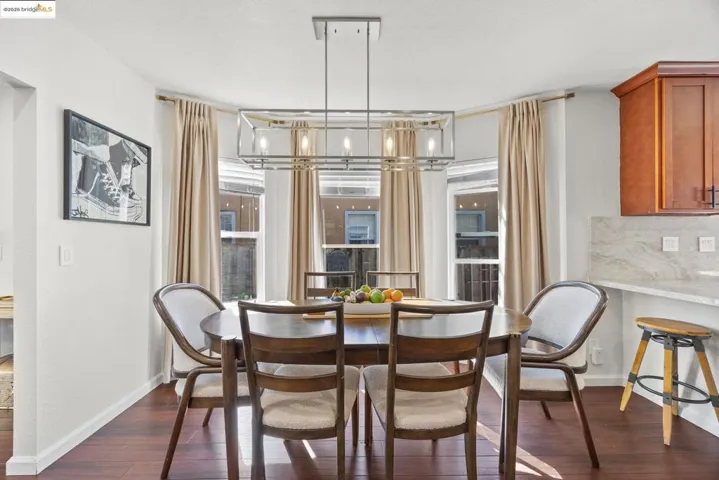 Dining area featuring dark wood-type flooring and baseboards