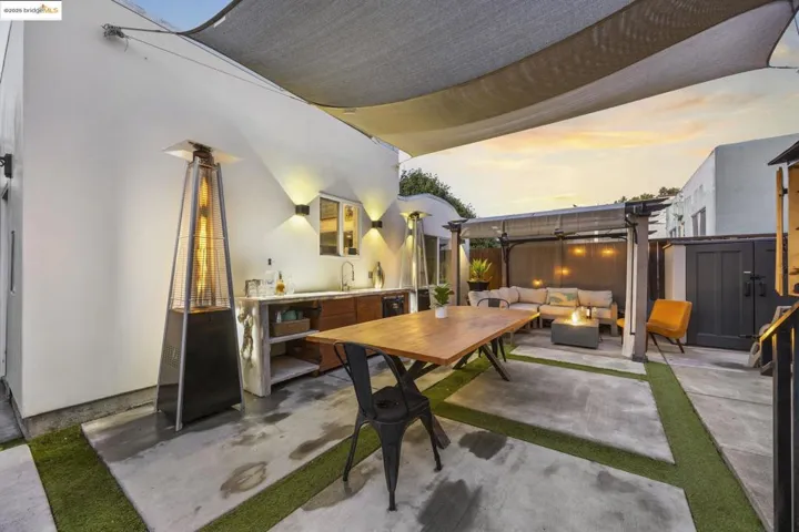 View of backyard featuring an outdoor living space with a fire pit, outdoor dining area, exterior kitchen, a pergola, and a shed