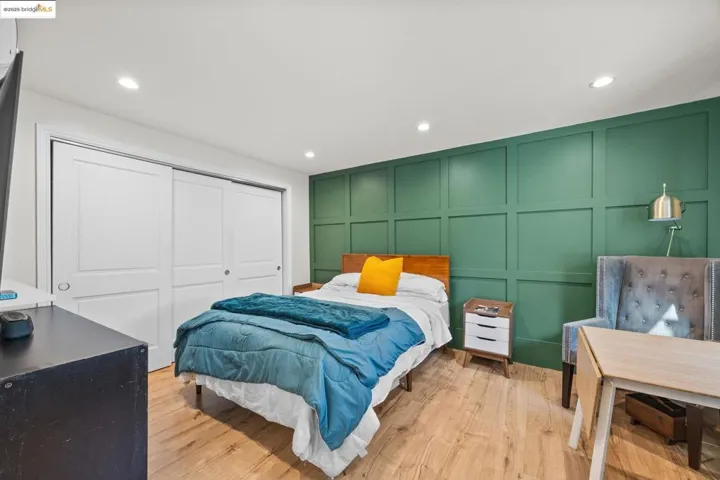 ADU- Bedroom featuring a decorative wall, recessed lighting, light wood-style floors, and a closet