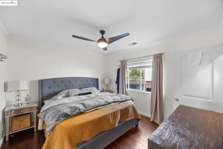 Bedroom featuring crown molding, dark wood-type flooring, and ceiling fan