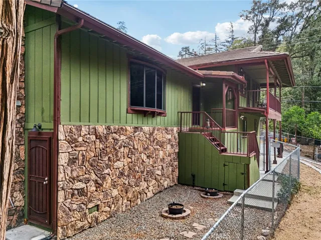 Side elevation with stone accents, gated walkway, and low-maintenance grounds.