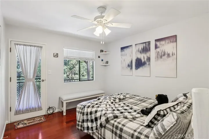 Guest bedroom with ceiling fan and direct deck access to the trees.