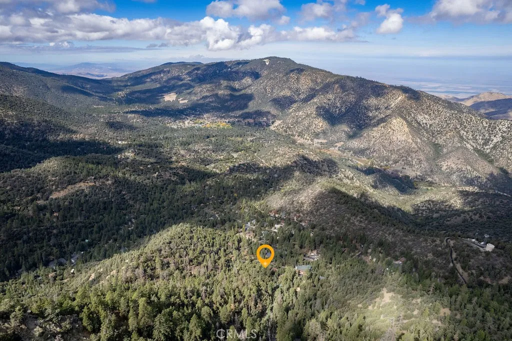 A mountain view lot on a paved street in the forest with community amenities nearby including the clubhouse, golf course, pool/spa, tennis/pickleball courts stables, park with picnic area, sports courts and hiking trails.