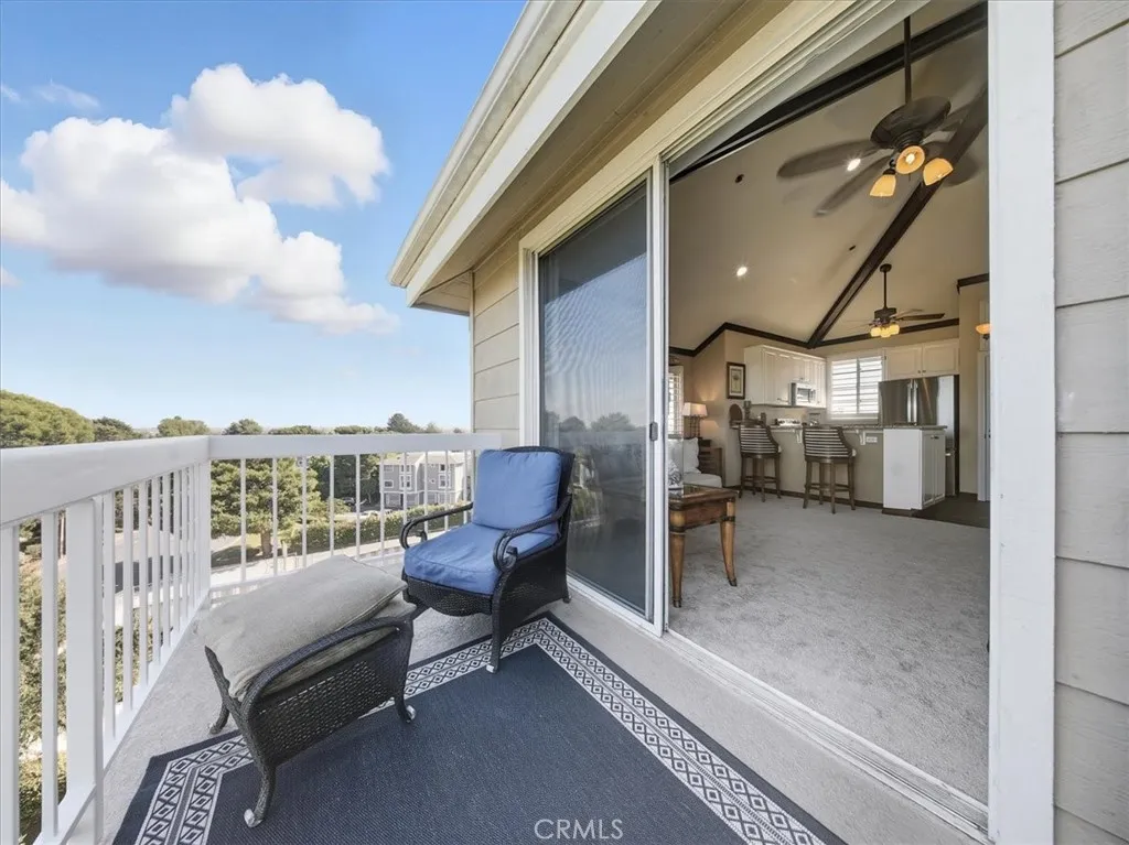 South-facing penthouse with panoramic views of Huntington Beach and Newport Coast. Inside, enjoy vaulted ceilings, elegant wood beams with decorative trim, and a sunlit living area that seamlessly blends indoor comfort with coastal vistas.