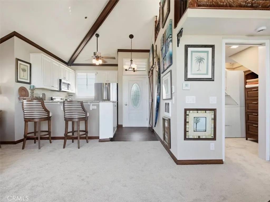 Penthouse balcony entry with leaded-glass front door opens to a bright sunlit interior featuring vaulted ceilings, new carpeting, loft retreat, kitchen bar seating, walk-in closet, and multiple ceiling fans throughout.
