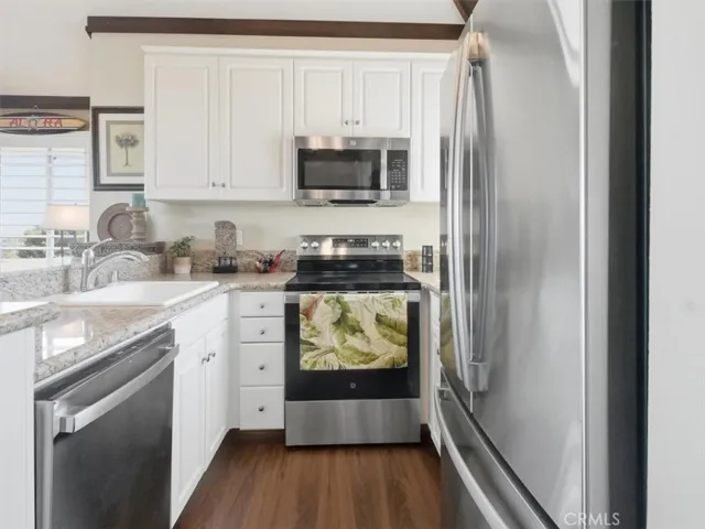 Bright and airy chef’s kitchen with modern appliances, illuminated by natural light streaming through the kitchen window.