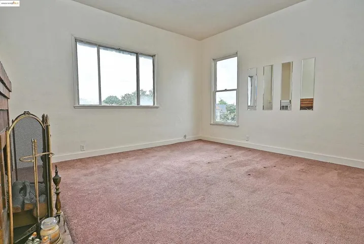 Empty room featuring plenty of natural light and light carpet