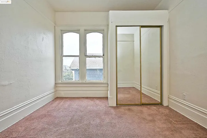 Unfurnished bedroom featuring a textured wall, carpet flooring, and a closet