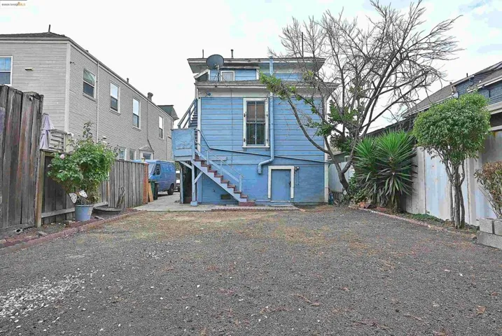 Back of property featuring a fenced backyard and stairway