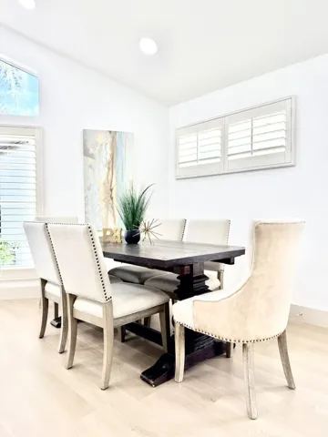 Formal dining area off the open concept kitchen with views of the lush backyard.