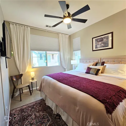 Private Bedroom with Roku TV and ceiling fan.
