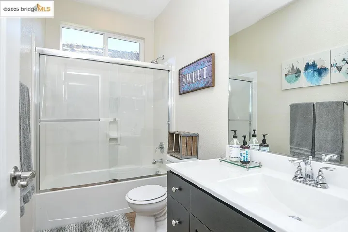 Full bath featuring enclosed tub / shower combo and vanity