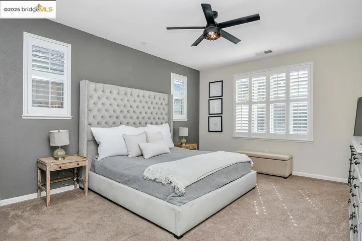 Bedroom featuring light colored carpet and a ceiling fan
