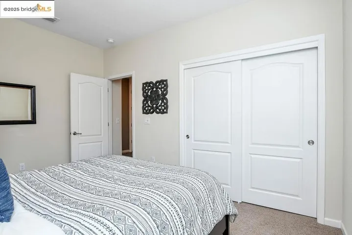 Carpeted bedroom featuring a closet and baseboards
