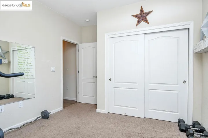 Workout room featuring light carpet and baseboards