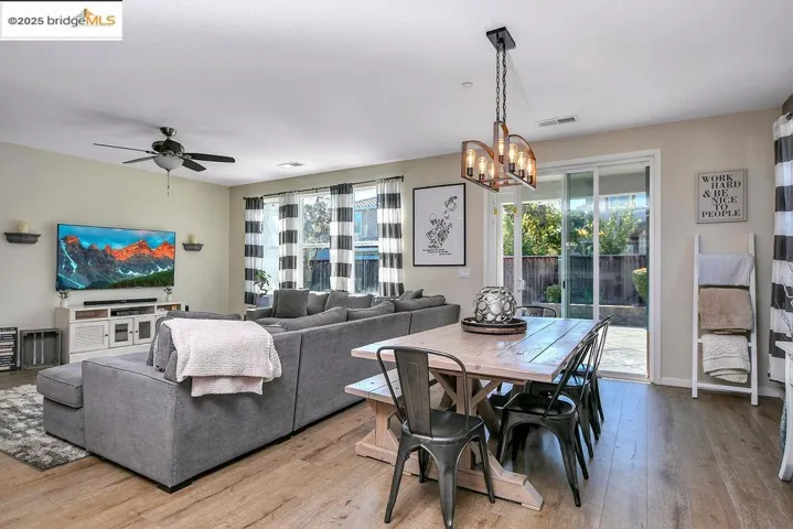 Dining room with wood finished floors, a chandelier, and ceiling fan